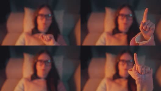 美丽的女人躺在沙发上的肖像和使用智能眼镜。元境智能眼镜虚拟现实技术概念高清在线视频素材下载
