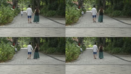 年轻的亚洲华人家庭在公园散步高清在线视频素材下载