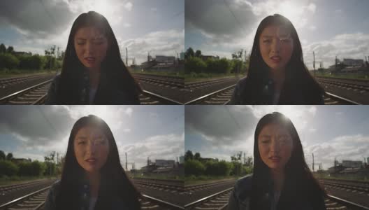 亚洲年轻女子在铁路上哭泣。高清在线视频素材下载