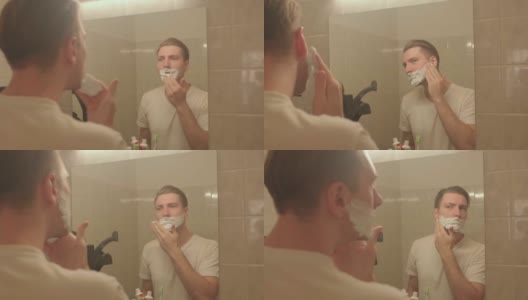 男士将剃须泡沫涂在脸上。他在算盘上搓手，准备刮脸。高清在线视频素材下载