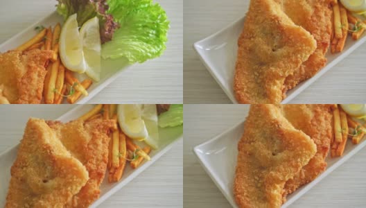 炸鱼和薯条-炸鱼片与土豆片和柠檬在白色盘子高清在线视频素材下载