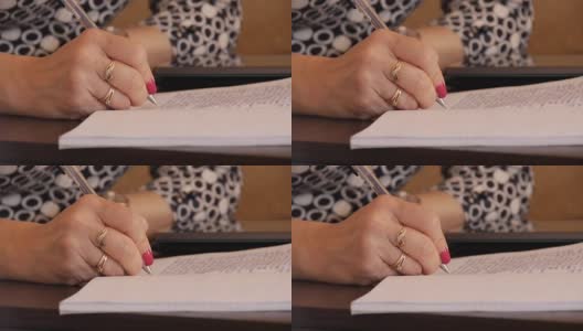 一位妇女用圆珠笔在笔记本上手写文字高清在线视频素材下载