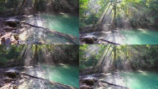 瀑布和美丽的热带自然与阳光透过树。泰国北碧府四面瀑布。4k分辨率高清在线视频素材下载