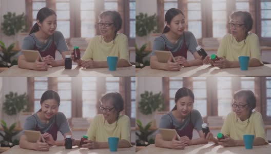 亚洲家庭在客厅，而女儿帮助她的母亲视频电话与男医生在家远程医疗高清在线视频素材下载