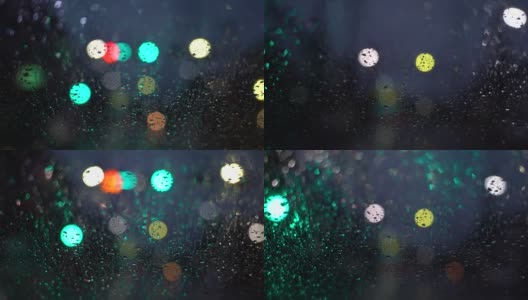 在雨夜开车。从车流中聚集的模糊光线，雨水打在前镜上。视频缓慢的运动。高清在线视频素材下载