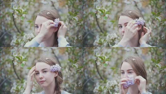 年轻女子的肖像在花园女孩在她的头发上枝丁香高清在线视频素材下载