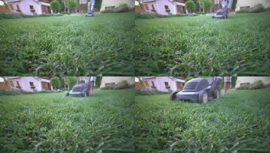 在花园工作的房主使用割草机修剪草坪高清在线视频素材下载
