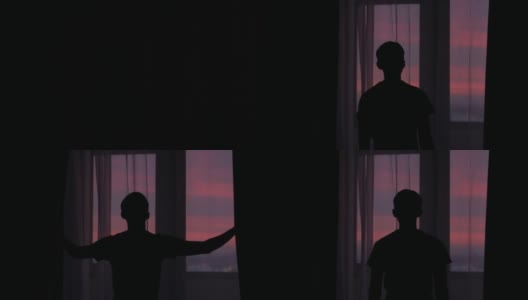 夕阳西下，一个年轻人拉开窗帘的剪影高清在线视频素材下载