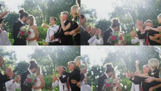 新郎新娘亲吻4K的时候，客人们扔花瓣高清在线视频素材下载