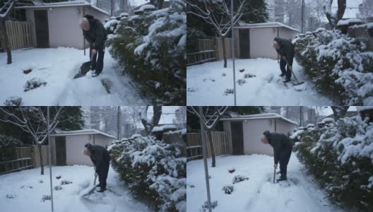 一个老人在前院用雪铲铲雪高清在线视频素材下载