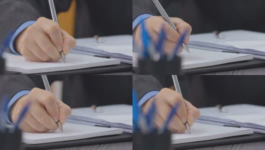 男性的手在笔记本上用笔写字。特写镜头。多莉拍摄高清在线视频素材下载