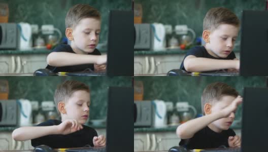 7 ~ 9岁的白人男孩正坐在家里的笔记本电脑屏幕前，专心致志地敲打着键盘。左边是Copyspace。上网的孩子，在家的生活方式。家庭教育高清在线视频素材下载