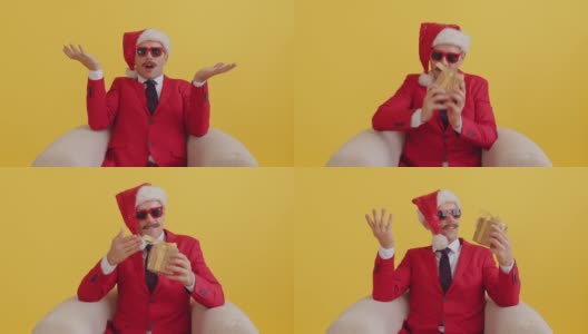穿着红色西装、戴着圣诞老人帽、戴着红色滑稽眼镜的小胡子男子坐在椅子上，突然收到一份惊喜礼物，感到很开心。新年销售和促销惊喜哇概念高清在线视频素材下载