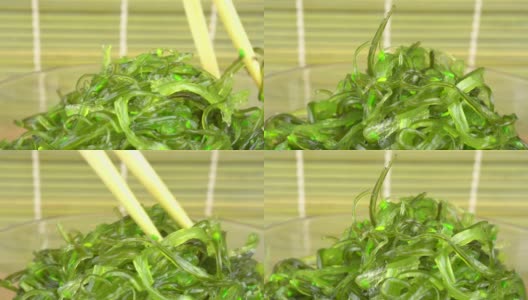 一个女人用筷子夹起楚卡海草。丘卡海草在玻璃碗的架子上高清在线视频素材下载