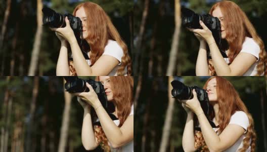 被太阳亲吻的红发女孩拿着相机微笑着看日落。高清在线视频素材下载