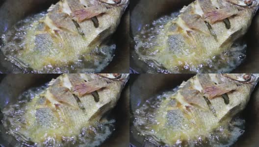 在锅里进行煎炸的罗非鱼(近景)高清在线视频素材下载