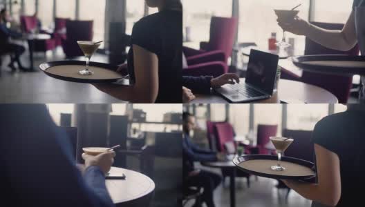 一个服务员用托盘端着一杯鸡尾酒，给一个在餐厅里通过笔记本电脑上网工作的忙碌男士高清在线视频素材下载