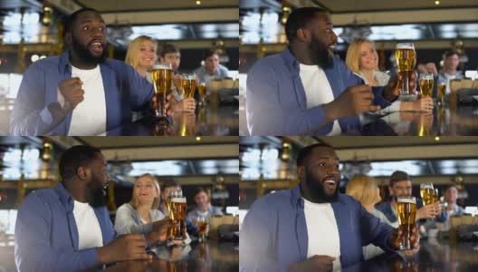 不同种族的朋友举起啤酒杯，庆祝运动队的成功高清在线视频素材下载