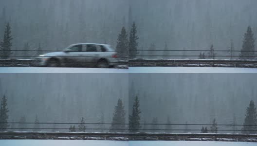 在冬季暴风雪期间，在科罗拉多州的落基山脉70号州际公路上缓慢行驶的车辆的侧面视图高清在线视频素材下载