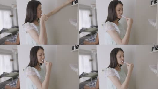 年轻女人穿着睡衣在早上刷牙高清在线视频素材下载