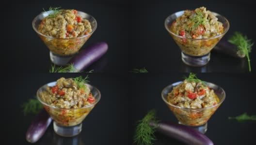 煮熟的夏季茄子鱼子酱与蔬菜在一碗黑色的背景高清在线视频素材下载