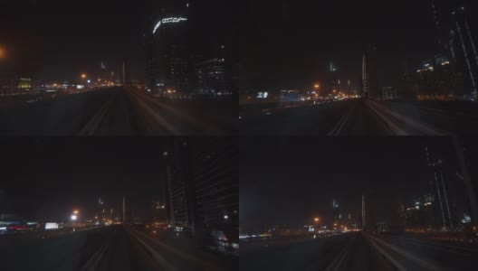 迪拜地铁在夜间驶过市中心的摩天大楼。地铁列车在地铁轨道上快速行驶的第一人称视角高清在线视频素材下载