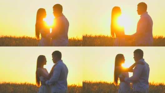 浪漫的年轻幸福的夫妇剪影在金色的麦田日落。女人和男人在阳光下拥抱亲吻，太阳镜头的光晕。爱，幸福的家庭，自然，户外。慢镜头,120 fps高清在线视频素材下载