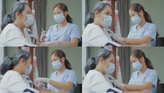 年长的亚洲妇女害怕在家里接受Covid-19冠状病毒疫苗，对护士使用医疗注射器注射疫苗的看法。一位老人被隔离在家里，公寓里。高清在线视频素材下载