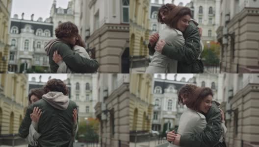 一对深情的情侣在街上拥抱。在城市背景下男人围着女人转。高清在线视频素材下载