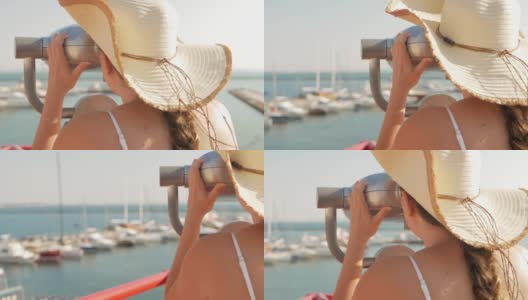 穿着沙滩服戴着沙滩帽的女人用固定的双筒望远镜看。双筒望远镜在海面附近的观察甲板上。在敖德萨港口。码头上的豪华游艇。商用机器，自动售货业务。高清在线视频素材下载