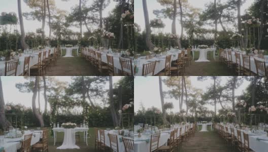 令人惊叹的婚礼布置在花园，白色桌布和木制椅子的桌子。美丽的节日气氛。花园里到处都是粉红色和白色的玫瑰。高清在线视频素材下载
