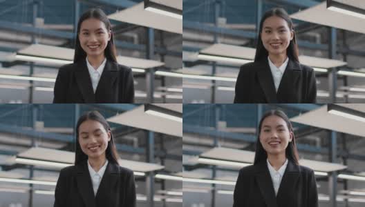 快乐的韩国商业女士微笑着对着照相机摆姿势在办公室高清在线视频素材下载