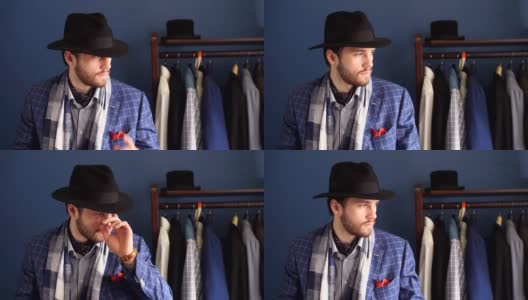 优雅的男子在时装套装和帽子摆姿势在工作室与饮料高清在线视频素材下载