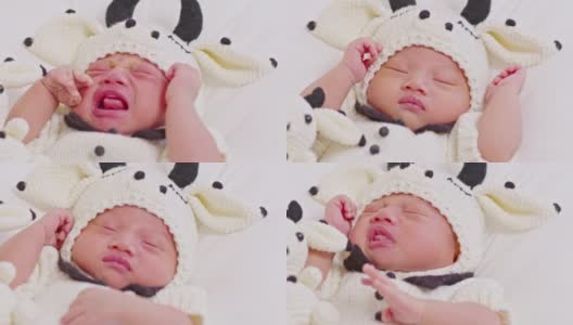 快乐的新生儿穿着可爱的奶牛服装躺在白色的背景上睡觉舒适和安全。可爱的亚洲婴儿在婴儿床上睡觉和打盹高清在线视频素材下载