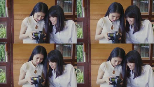 快乐的亚洲女性朋友在咖啡厅咖啡厅看数码相机照片高清在线视频素材下载