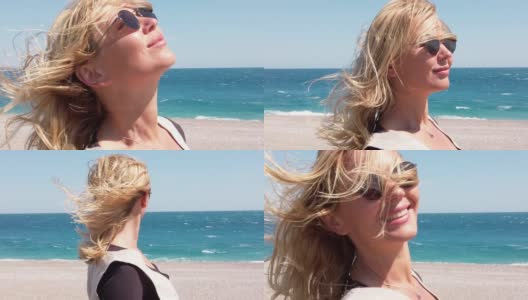 在一个多风的日子在海滩上美丽的女人的慢动作视频高清在线视频素材下载