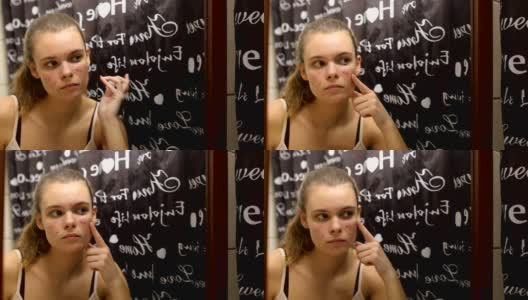 十几岁的女孩在浴室里往脸上涂抹精油高清在线视频素材下载