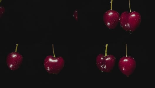 两颗樱桃撞击黑色背景的慢镜头高清在线视频素材下载