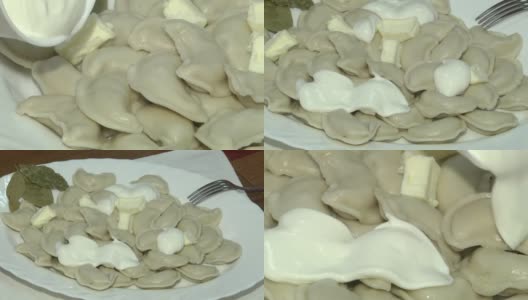 水饺配酸奶油。白色的盘子与水煮饺子。高清在线视频素材下载