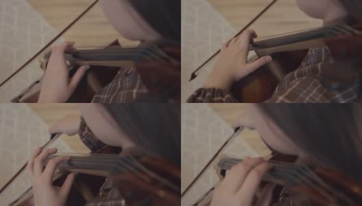年轻女子音乐家与弓在家中演奏大提琴室内高清在线视频素材下载