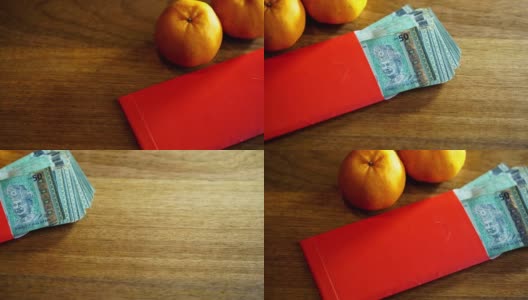 橘子和带有马来西亚货币的木制背景的中国红包高清在线视频素材下载