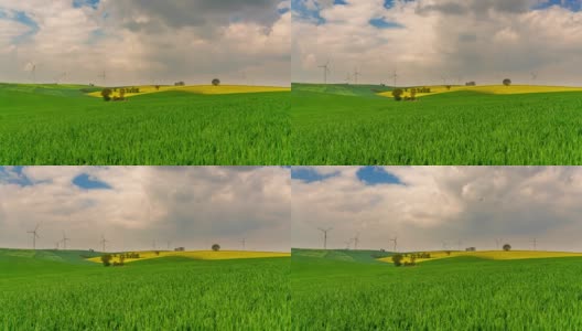T/L Cloudscape在绿色的田野上，风力涡轮机在远处旋转高清在线视频素材下载