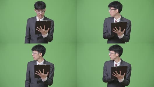年轻的亚洲商人一边看书一边聊天高清在线视频素材下载