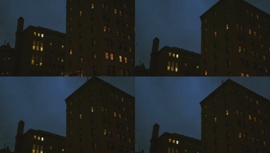 夜间，摄像机拍摄了这座城市的一座砖砌公寓楼高清在线视频素材下载