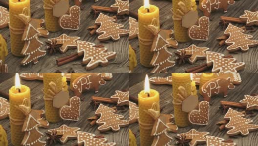 圣诞节自制的姜饼曲奇放在木桌上。由天然蜂蜡制成的黄色香味蜡烛。高清在线视频素材下载