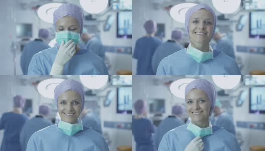 手术室手术成功后，积极、迷人、微笑的护士摘下手术口罩肖像。高清在线视频素材下载