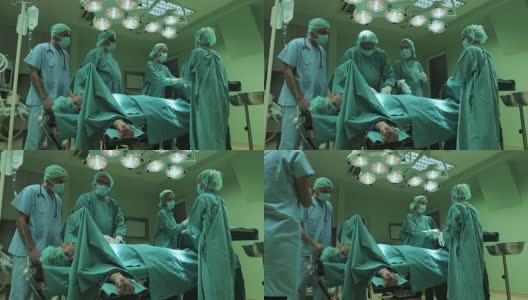 一组外科医生在准备对男性病人进行手术时进行合作。高清在线视频素材下载