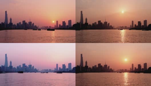 时间流逝镜头在上海城市日落与外滩天际线和黄浦江背景，货船在河上航行，太阳下降到地平线，4k视频。高清在线视频素材下载