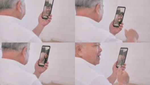亚洲老爷爷在视频会议上与在国外怀孕的女儿家庭视频通话，在社会距离中使用智能手机和视频会议技术。社会电话会议高清在线视频素材下载