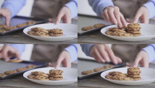 一个女人的手拿着一块饼干。用巧克力滴在烤盘上烘焙饼干高清在线视频素材下载